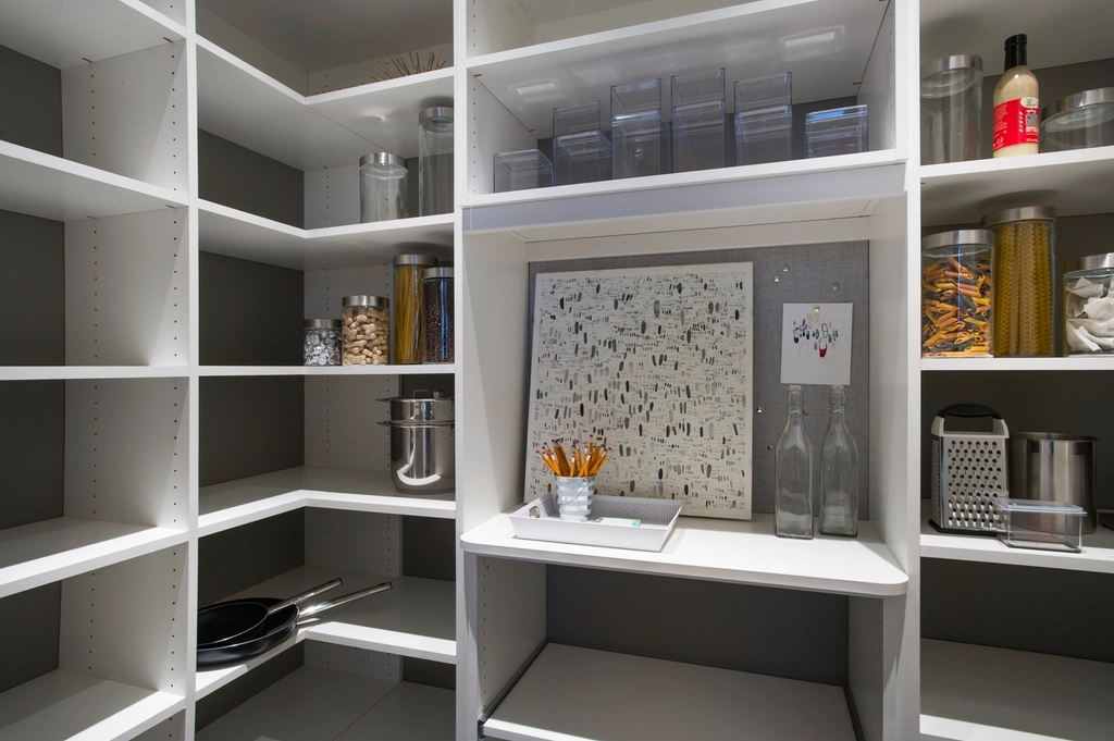 Walk-in pantry lined with white shelving
